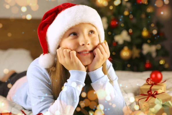 Menina bonita faz desejos ou sonhos no interior do Natal Imagens Royalty-Free