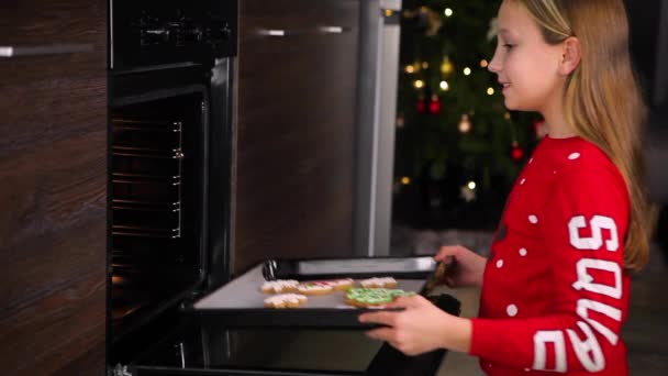 Genç kız evde zencefilli kurabiye pişiriyor. — Stok video