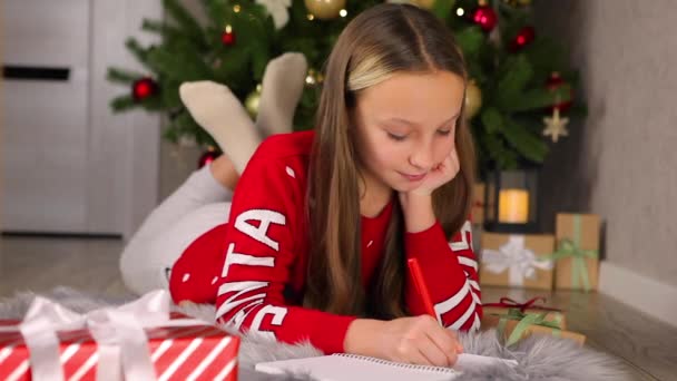 Gyermek egy díszített belső karácsonyra levelet ír a Mikulás — Stock videók