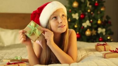 Noel için dekore edilmiş bir evde çocuk bayram hediyelerini açıyor. 