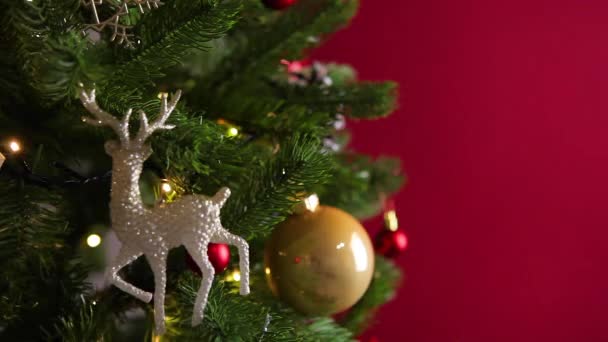 Pigen lægger en gave på et dekoreret juletræ. Julebaggrund – Stock-video