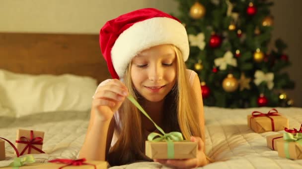 Il bambino a casa in un interno decorato per Natale apre regali di vacanza — Video Stock