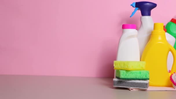 Conjunto de produtos de limpeza sobre a mesa em um fundo colorido . — Vídeo de Stock