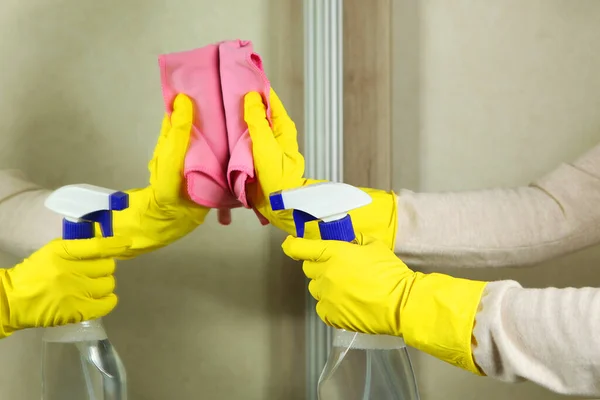 Mulher de luvas limpa o espelho com detergentes close-up — Fotografia de Stock