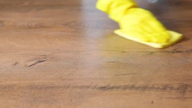 Ev hanımı masa yüzeyini temizler ve dezenfekte eder.