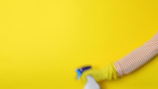 Spray for cleaning and disinfection on a colored background in female hands — Video Stock