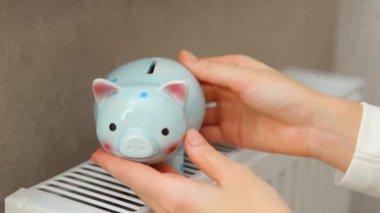 Bir radyatörün arka planında kadın ellerine bırakılmış dolar banknotları..