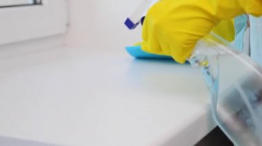 Temizlik yapan kadın pencere pervazını siler.