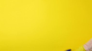 Temizlik ve dezenfeksiyon spreyi kadınların elinde renkli bir arka planda.