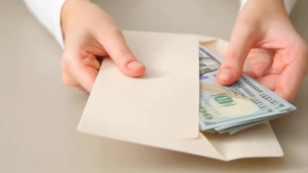 Het meisje haalt dollars uit de envelop close-up — Stockvideo