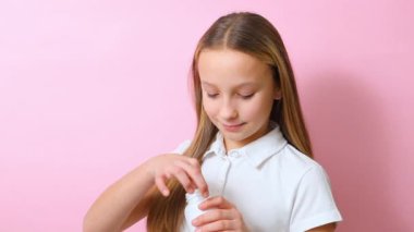 Genç kız, Omega 3 kapsüllerini renkli arka planda yakın plan çekimde kullanıyor.