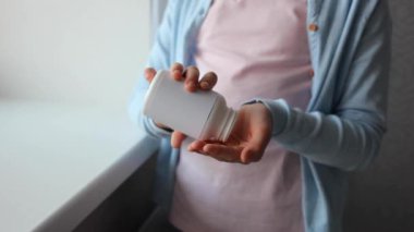 Genç kız, odanın içinde Omega 3 kapsülleri kullanıyor.