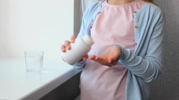 Nastolatka bierze omega 3 kapsułki we wnętrzu pokoju — Wideo stockowe