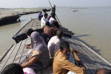 Bangladeş 24 Eylül 2021: Yerliler Rawmari, Kurigram, Bangladeş kırsal köy bölgesinde yolcu botlarının tepe örtüsü üzerinde seyahat ediyorlar.    