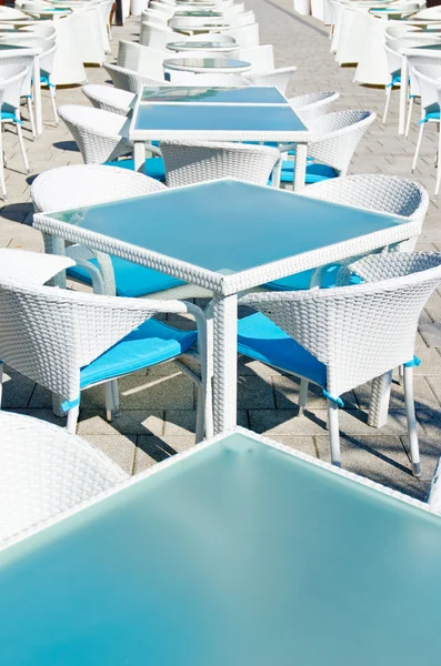 Rows of empty tables and chairs in an open air cafe bar — Stock Photo, Image