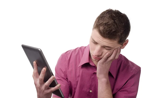 Jovem entediado segurando um tablet . — Fotografia de Stock