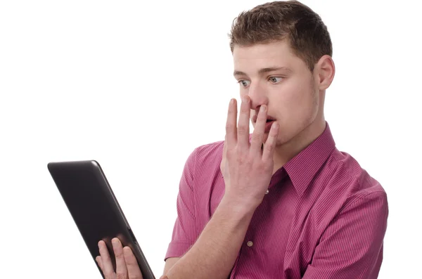 Mladý muž čtení šokující zprávy o tabletu. Stock Obrázky