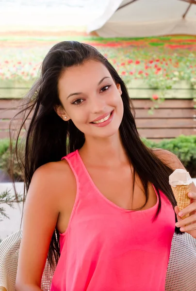 Красивая женщина улыбается и держит мороженое . — стоковое фото