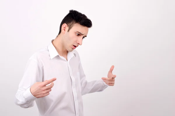 Homem de camisa branca a olhar para baixo. Apontar, explicar, gesticular . — Fotografia de Stock