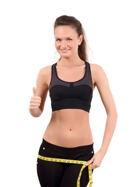 Thumbs up. Beautiful fit girl measuring her hips with a yellow measuring tape in inch. — Stock Photo, Image