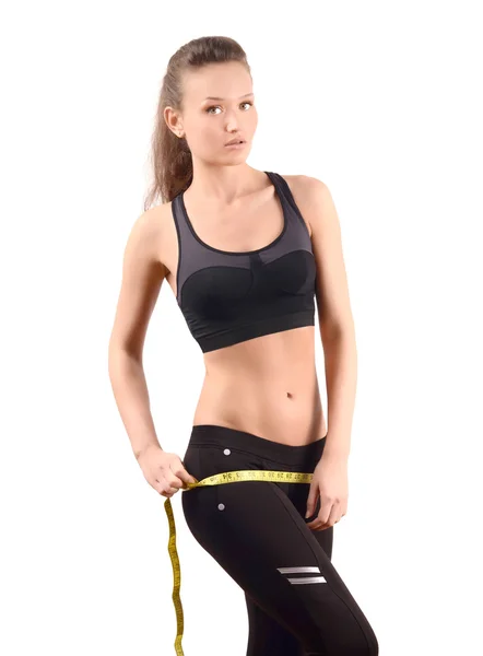 Beautiful fit girl measuring her hips with a yellow measuring tape in inch. — Stock Photo, Image