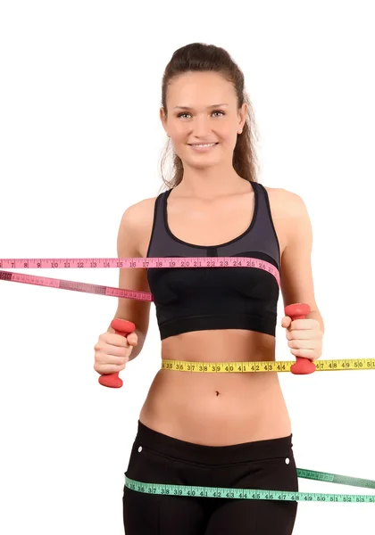 Beautiful fit girl with measuring tape around her bust, waist and hips holding dumbbells. — Stock Photo, Image