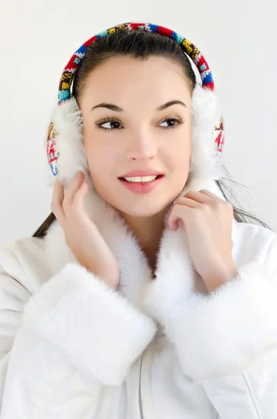 Çekici kız Beyaz önlük ve seyir uzağa muffs kulak giyiyor. — Stok fotoğraf