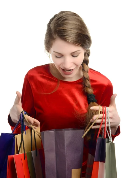 Mujer joven mirando dentro de las bolsas de la compra . — Foto de Stock