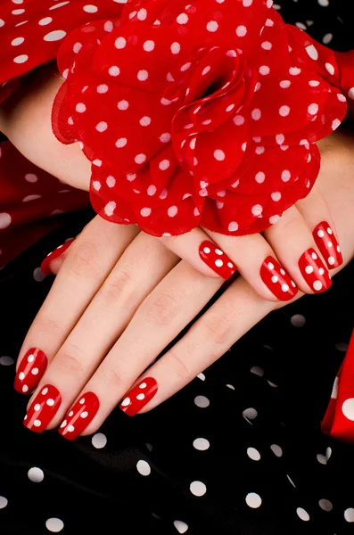 Close up on beautiful female hands with cute red manicure with white dots. — Stock Photo, Image