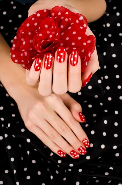 Close up on beautiful female hands with cute red manicure with white dots. — Stock Photo, Image