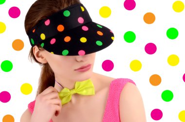 renkli polka noktalı şapkası ve neon yeşili papyon bir genç kadının portresi.