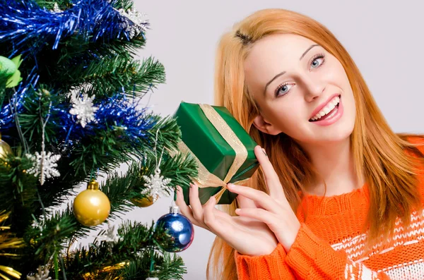 Schöne junge Frau lächelnd mit einem Weihnachtsgeschenk. — Stockfoto