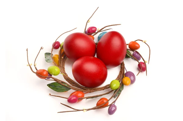 Ovos de páscoa tingidos à mão vermelha com decoração de ninho de ovo de Páscoa círculo em torno deles . — Fotografia de Stock