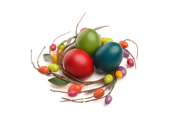 Colorful hand dyed easter eggs with circle easter egg nest decoration around them. — Stock Photo, Image