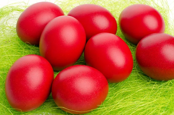 Close up su rosso mano tinti uovo di Pasqua su erba finta . — Foto Stock