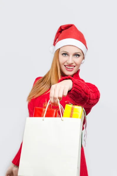 Mädchen in Rot mit vielen Einkaufstaschen und Geschenken. — Stockfoto