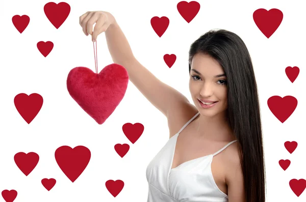 Beautiful brunette girl holding up a red heart. Happy woman, Valentine day. Hearts background. — Stock Photo, Image
