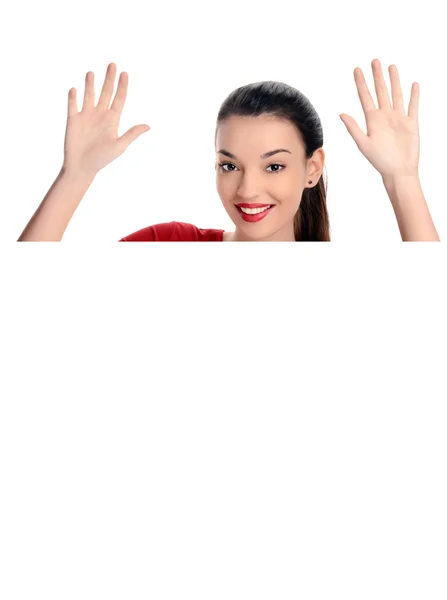 Retrato de uma bela mulher feliz levantando as mãos. Atrás de um cartaz em branco . — Fotografia de Stock