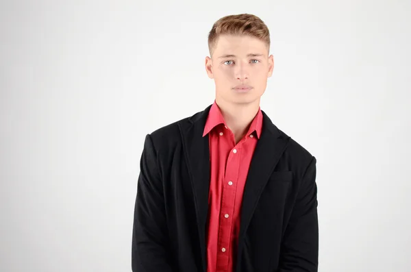 Retrato de um jovem homem de negócios vestindo um terno e uma camisa vermelha . — Fotografia de Stock