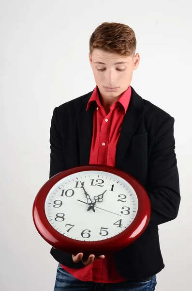 Geschäftszeit. Geschäftsmann hält und blickt auf eine große Uhr. — Stockfoto