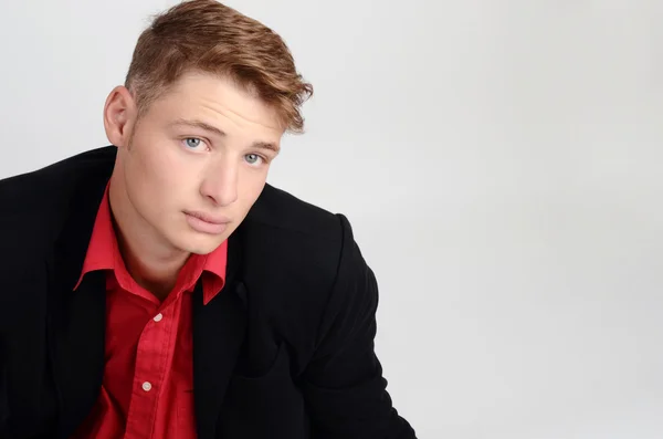 Portrait of a young business man wearing a black suit and a red shirt. Man looking up. — Stock Photo, Image