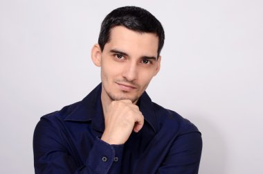 Adam kolunu çene gülümseyerek, ayakta.