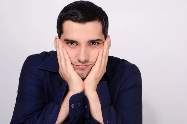 Mann sitzt mit dem Kopf in den Armen und wartet gelangweilt. — Stockfoto