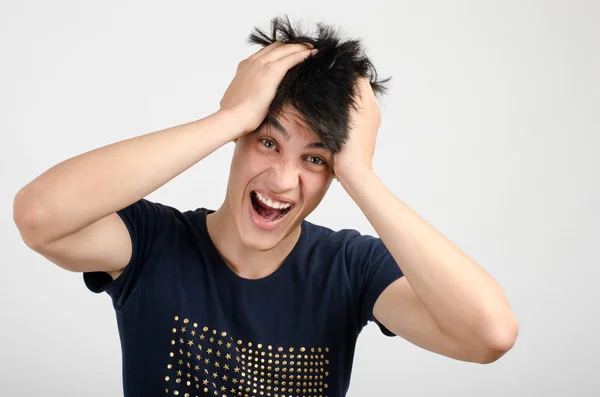 Joven sosteniendo su cabeza frunciendo el ceño con preocupación gritando. Hombre tirando de su oído para la preocupación, tristeza, desesperación . — Foto de Stock