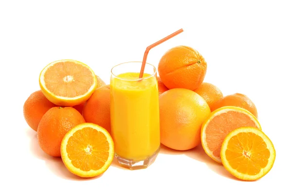 Montón de naranjas y un vaso de jugo de naranja fresco . — Foto de Stock