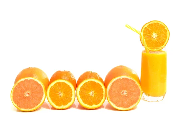 Grapefruit and oranges in a row with a glass of fresh orange juice. — Stock Photo, Image