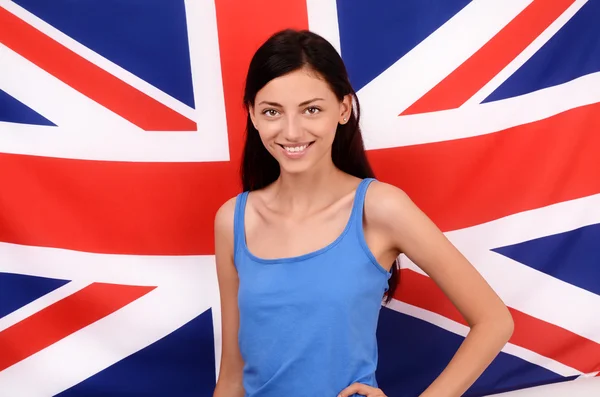 Portrait of a beautiful British girl smiling. Young woman standing with the UK flag in the background. — Stock Photo, Image