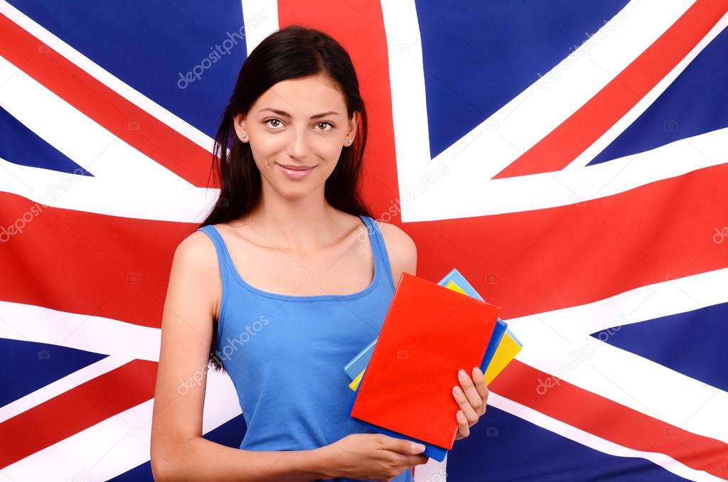 Learn English. Beautiful student holding books,red blank book cover.Young woman standing with the UK flag in the background.