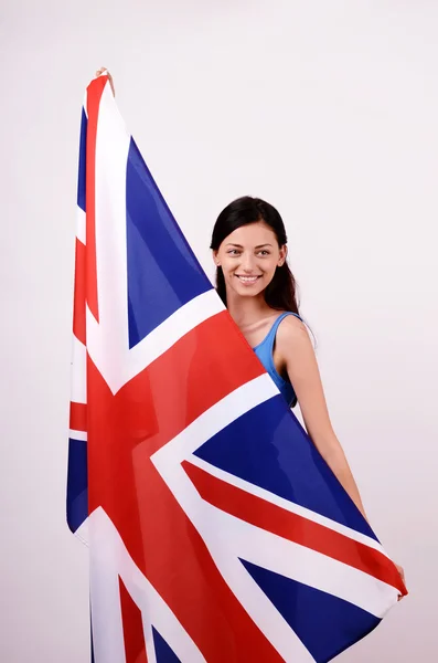 Menina britânica bonita sorrindo segurando a bandeira do Reino Unido olhando para longe . — Fotografia de Stock