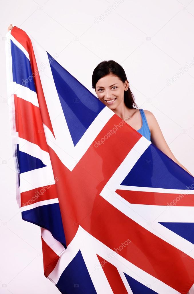 Beautiful British girl smiling holding up the UK flag.